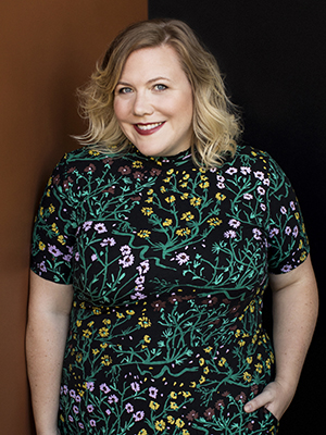 Lindy West headshot with black and green and pink floral dress