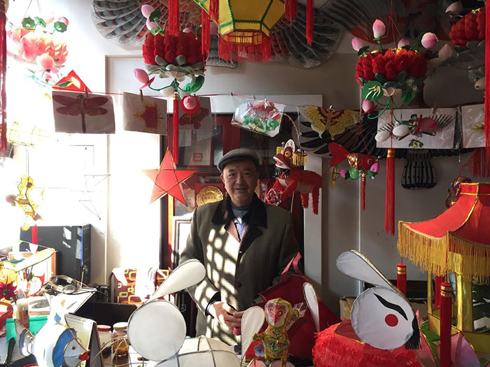 Man surrounded by handmade Chinese lanterns