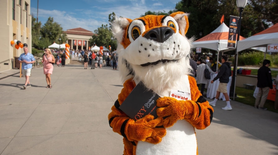 Oswald on campus holding an Oxy brochure