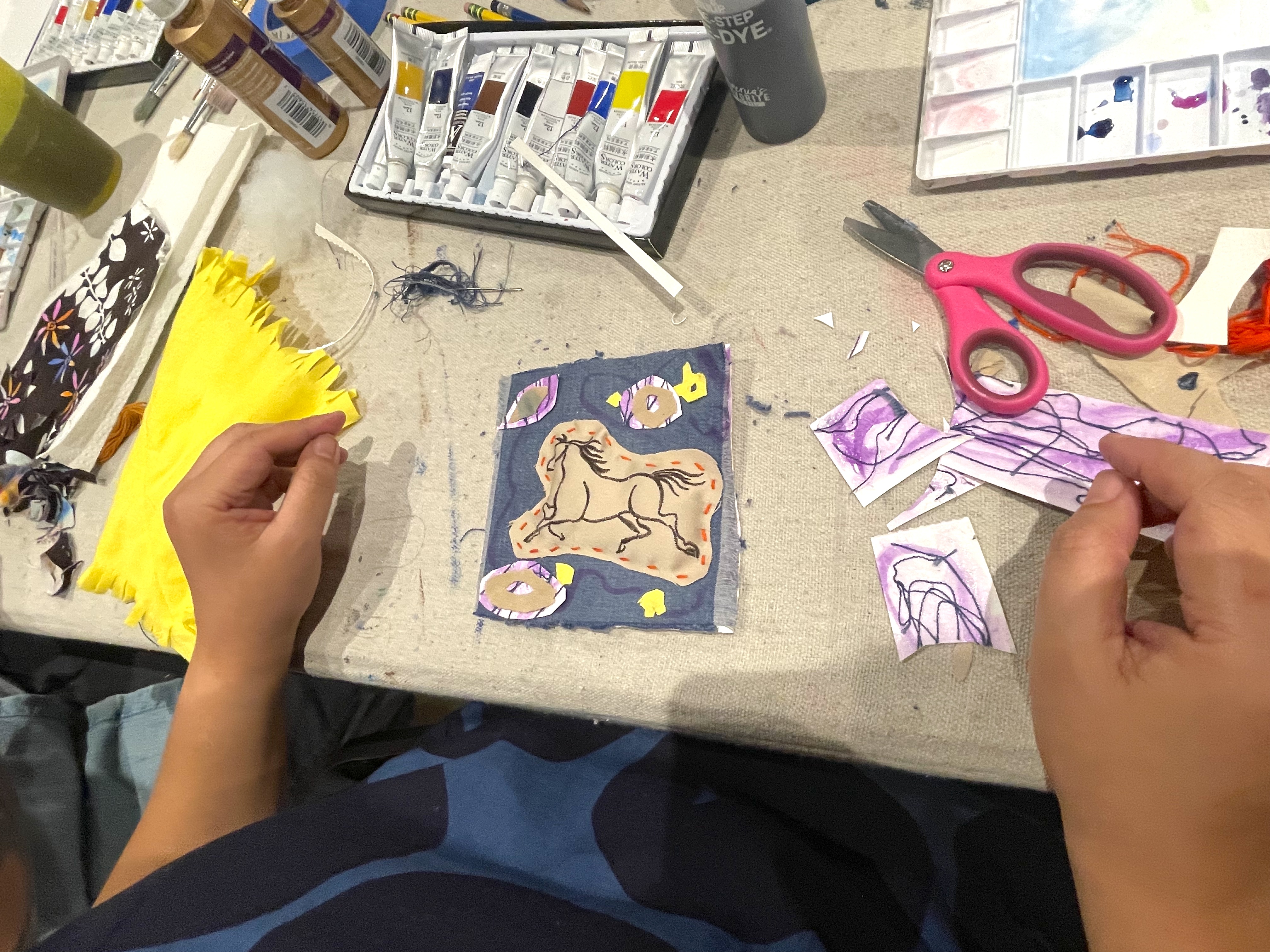 An artist making art with textiles and watercolor.