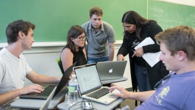 Prof. Mary Lopez talks with her students in the classroom