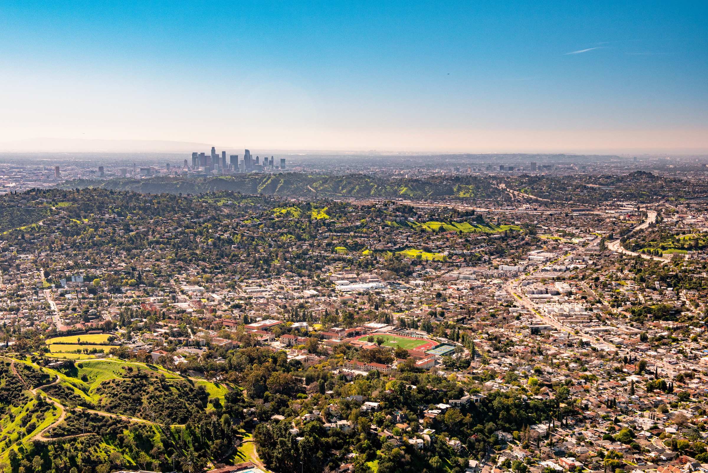 A view of campus from a drone with downtown LA in the background