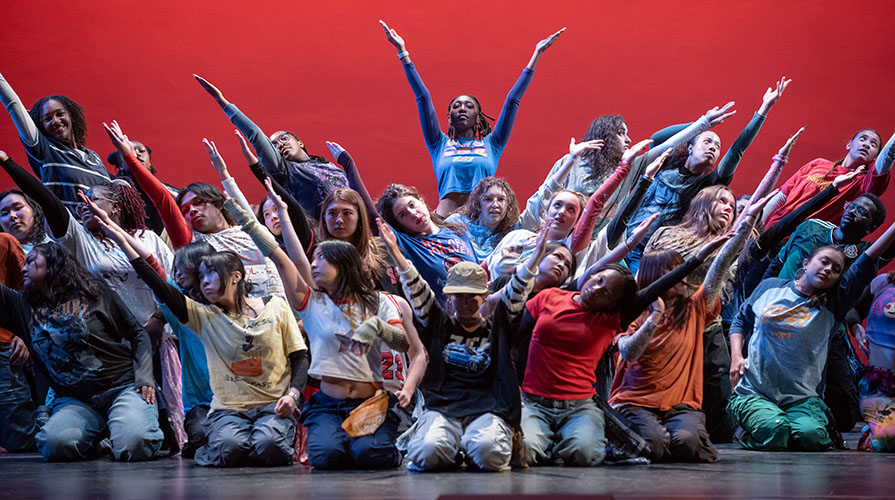Occidental College students in a large formation on stage during a Dance Pro rehearsal