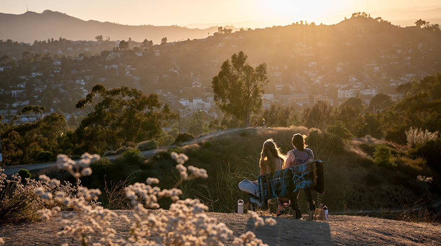 Two students in a sunset-bathed landscape on Fiji Hill with beautiful soft lighting
