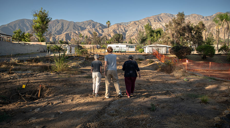 Graham Luethe with two of his Occidental professors on an empty lot in Altadena post-fires