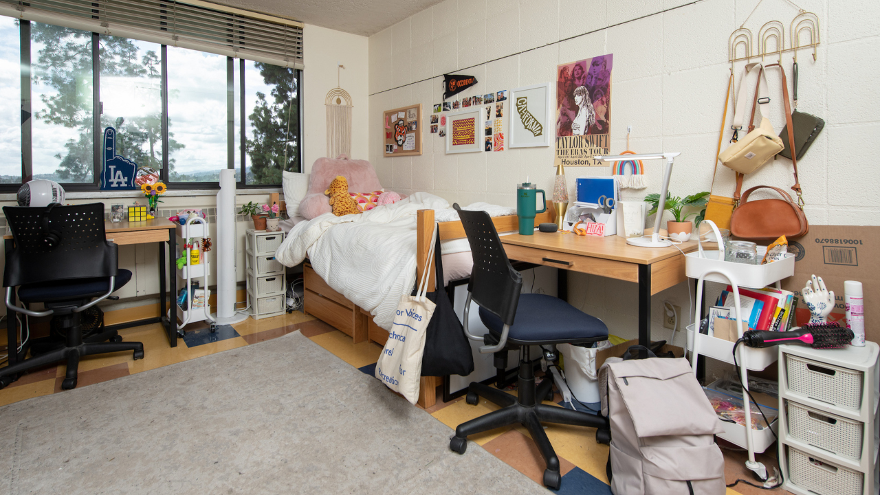 An Occidental College residence hall room with desk, furniture, a nice window and decorations on the walls