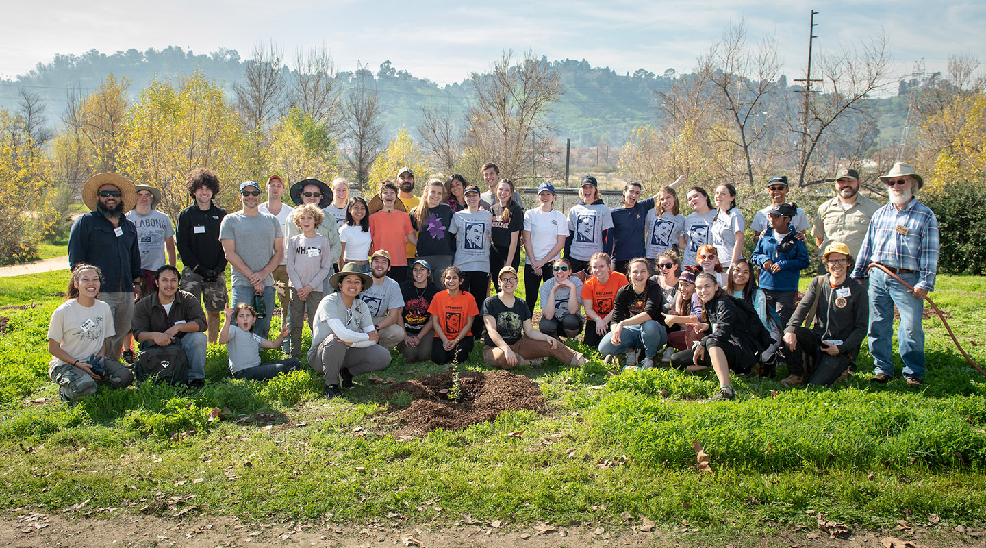 A large group of Occidental College garden volunteers stand together outdoors
