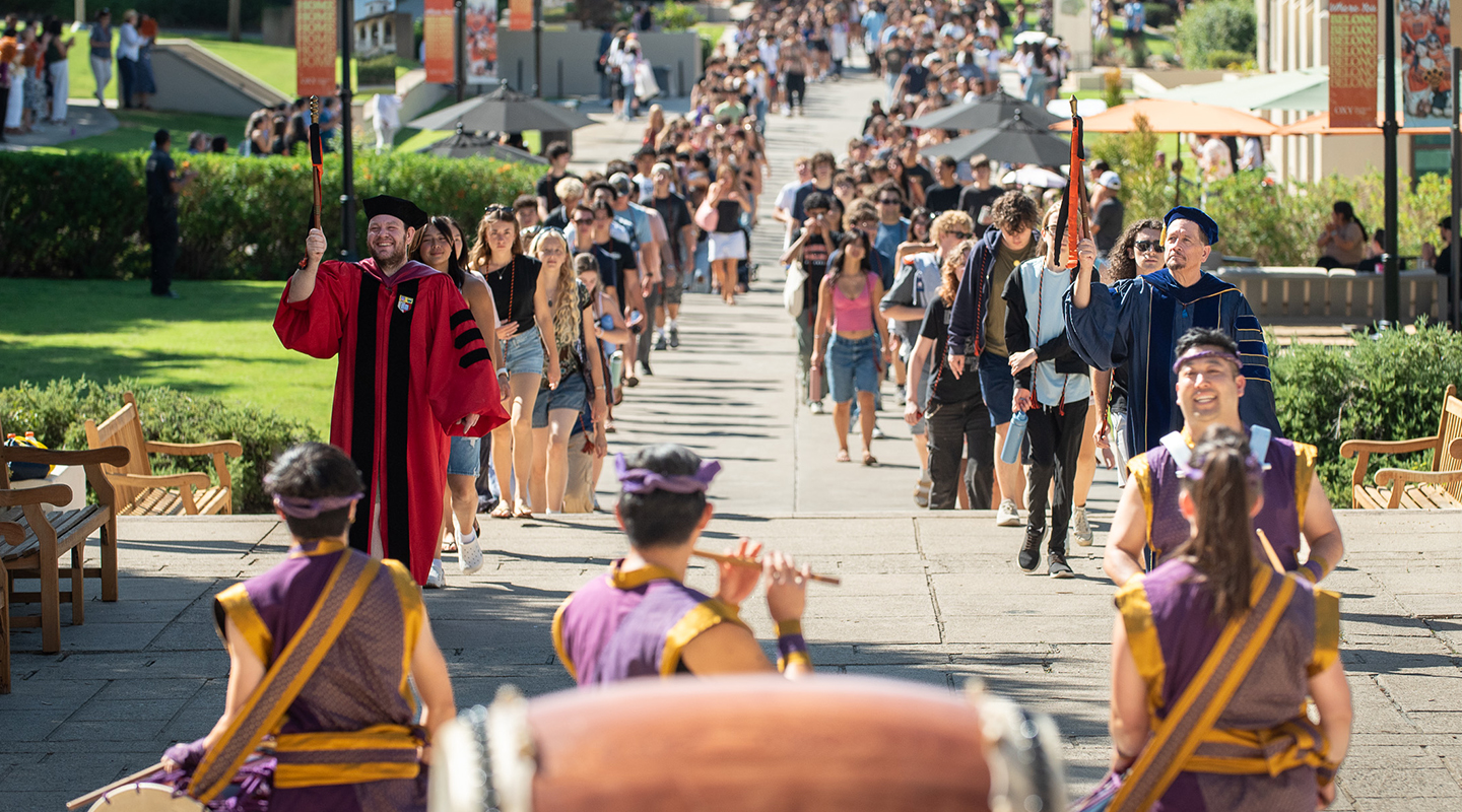 Two long lines of students walking up to Thorne Hall on campus for Convocation