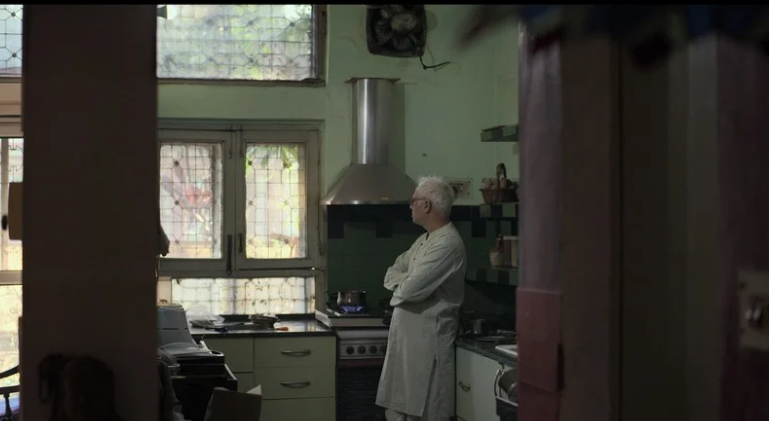 Old man in kitchen looking away from the camera