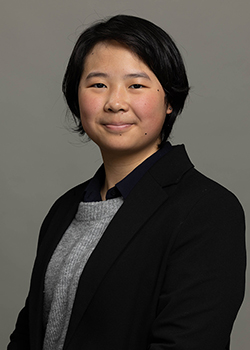 Alphonse has short black hair and is wearing a black suit