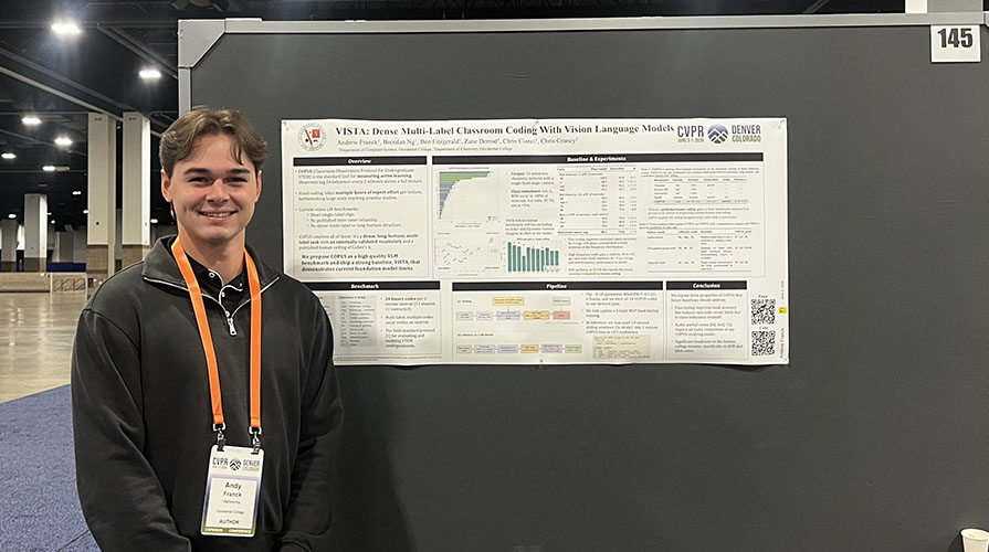 Oxy student Andy Franck '27 stands in front of a research poster at an academic conference