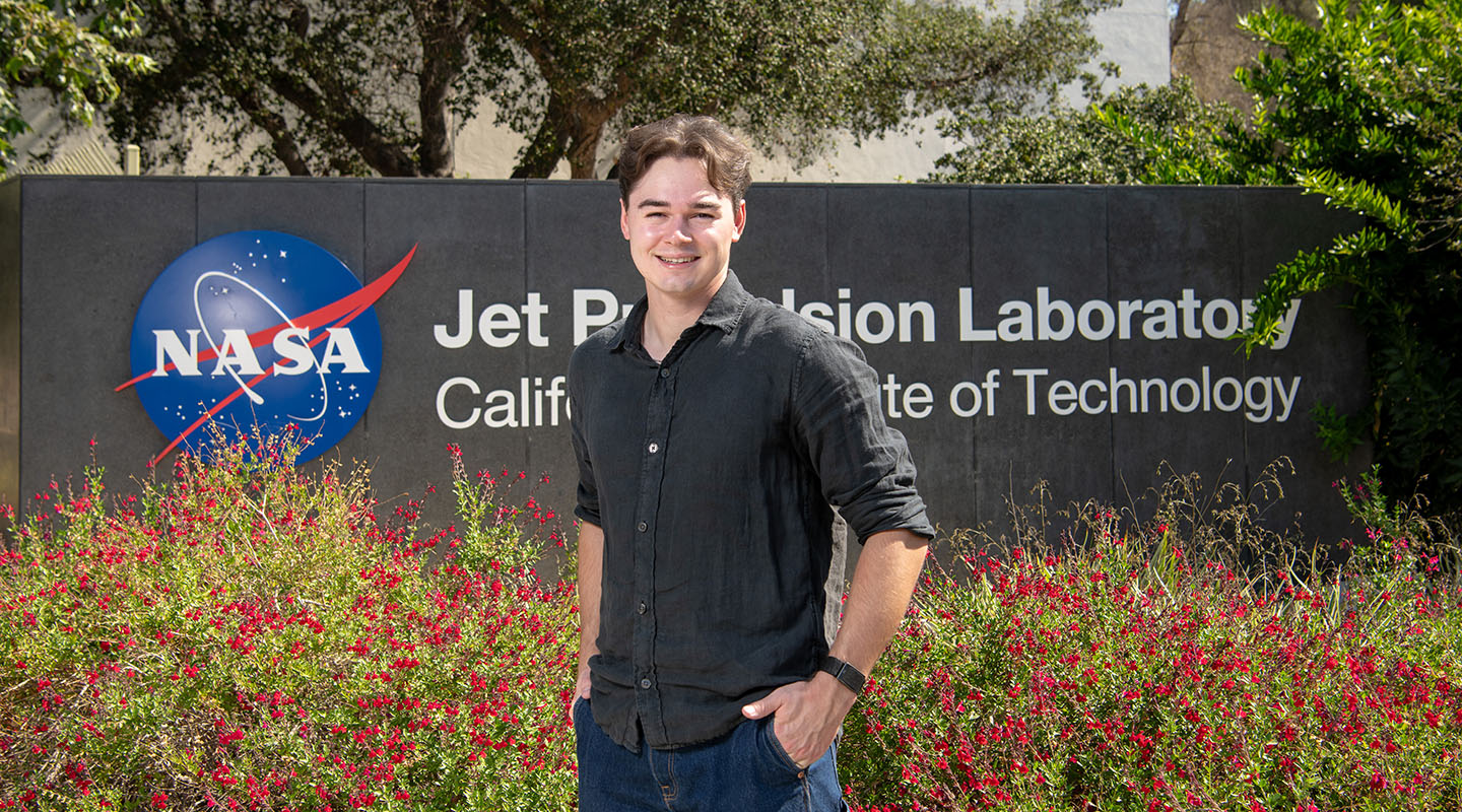 Oxy student Andy Franck '27 standing in front of the NASA JPL sign on the JPL campus
