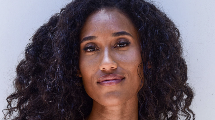 Headshot of Anna Tubbs with long curly dark hair