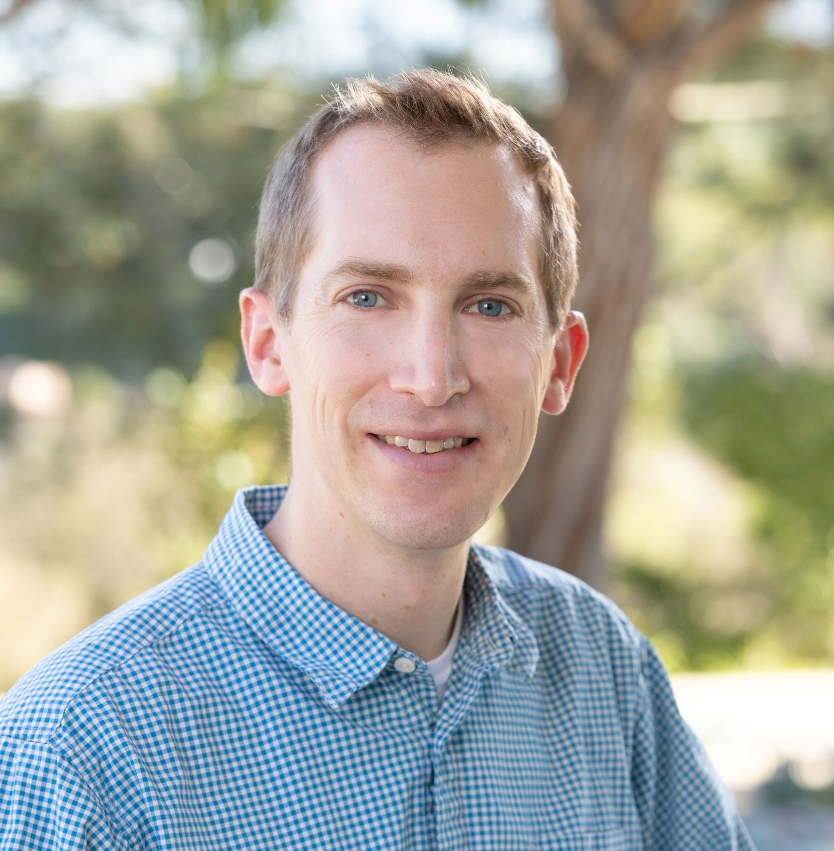 Dr. Brandon Taylor in front of a tree