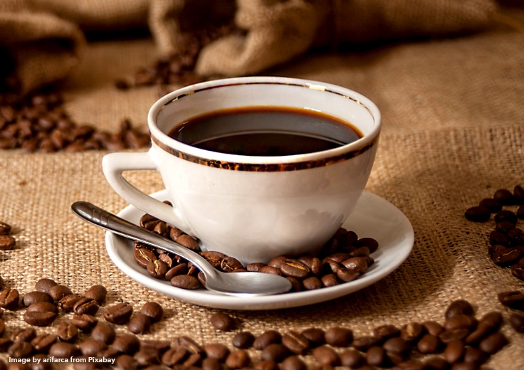 a hot cup of coffee in a porcelain coffee cup with spoon