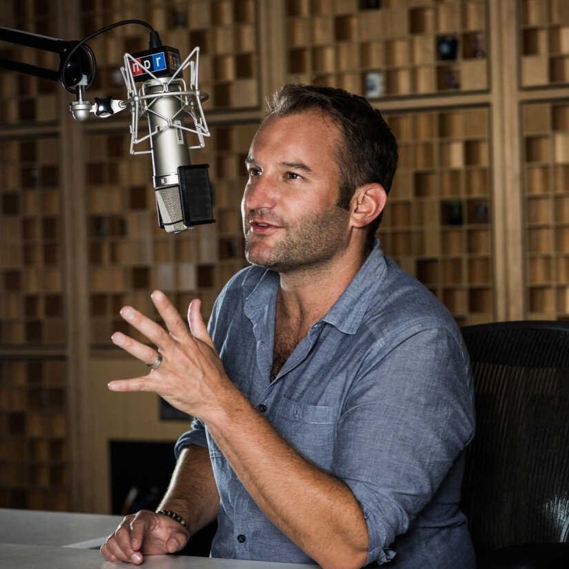 Journalist David Greene in a blue shirt talking into a radio mic