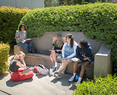 Four Occidental College students and their professor sit outside to have class