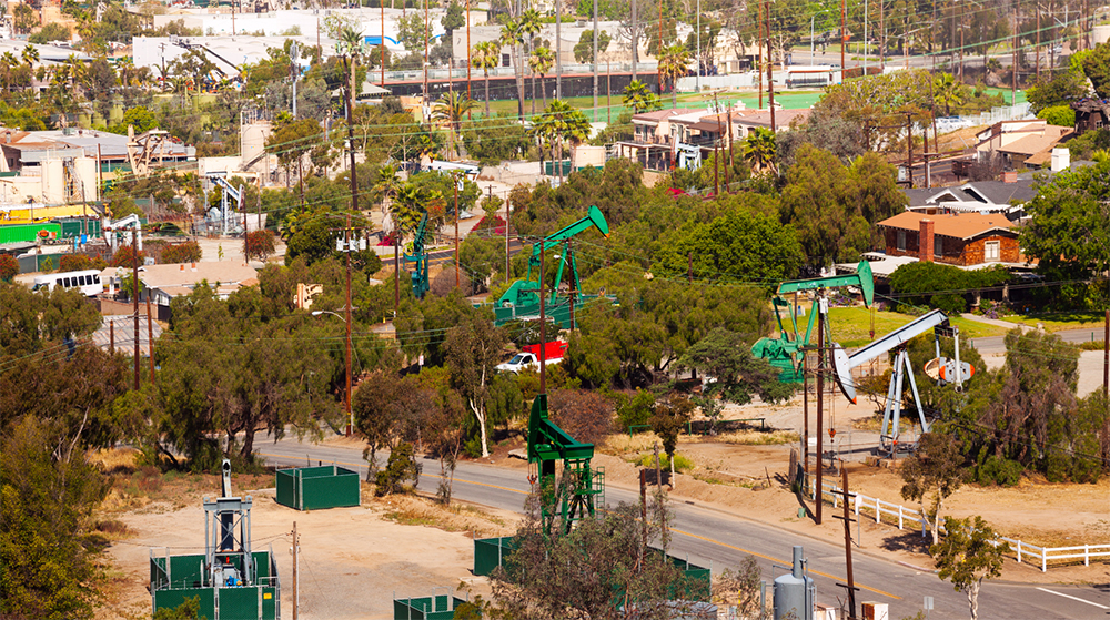 Oil derricks in a sub­urban California neighborhood