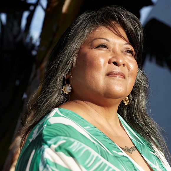 FAHM Portrait_2.1.jpg Portrait of a woman with long hair looking into the distance. She is wearing a green top.