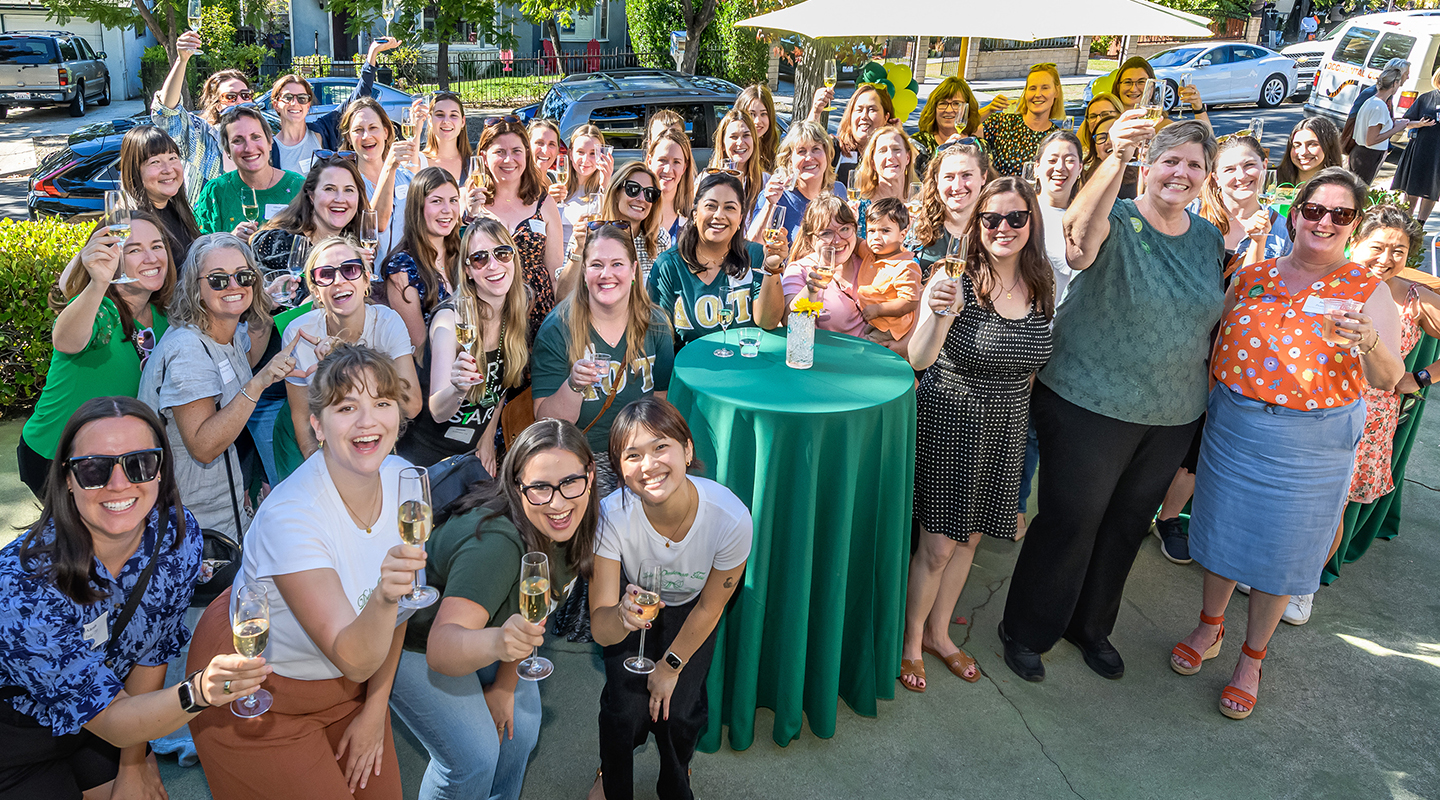 Members of Delta Omicron Tau spannng five decades raise a glass at the Delta House one last time on October 19.