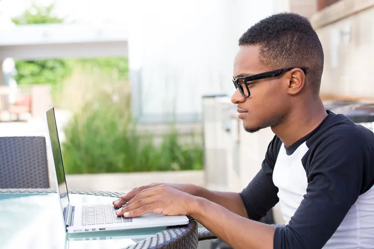 college student working on a laptop intently
