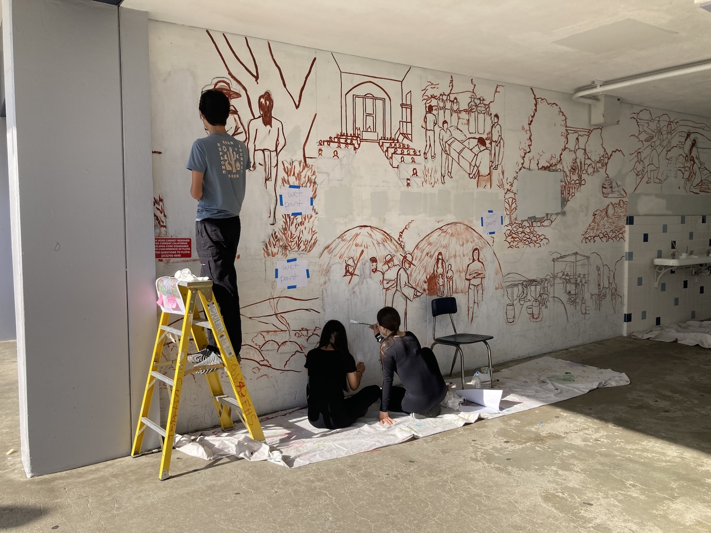 IMG_2879.jpg three students with their backs to the camera work on the in-progress Franklin Mural