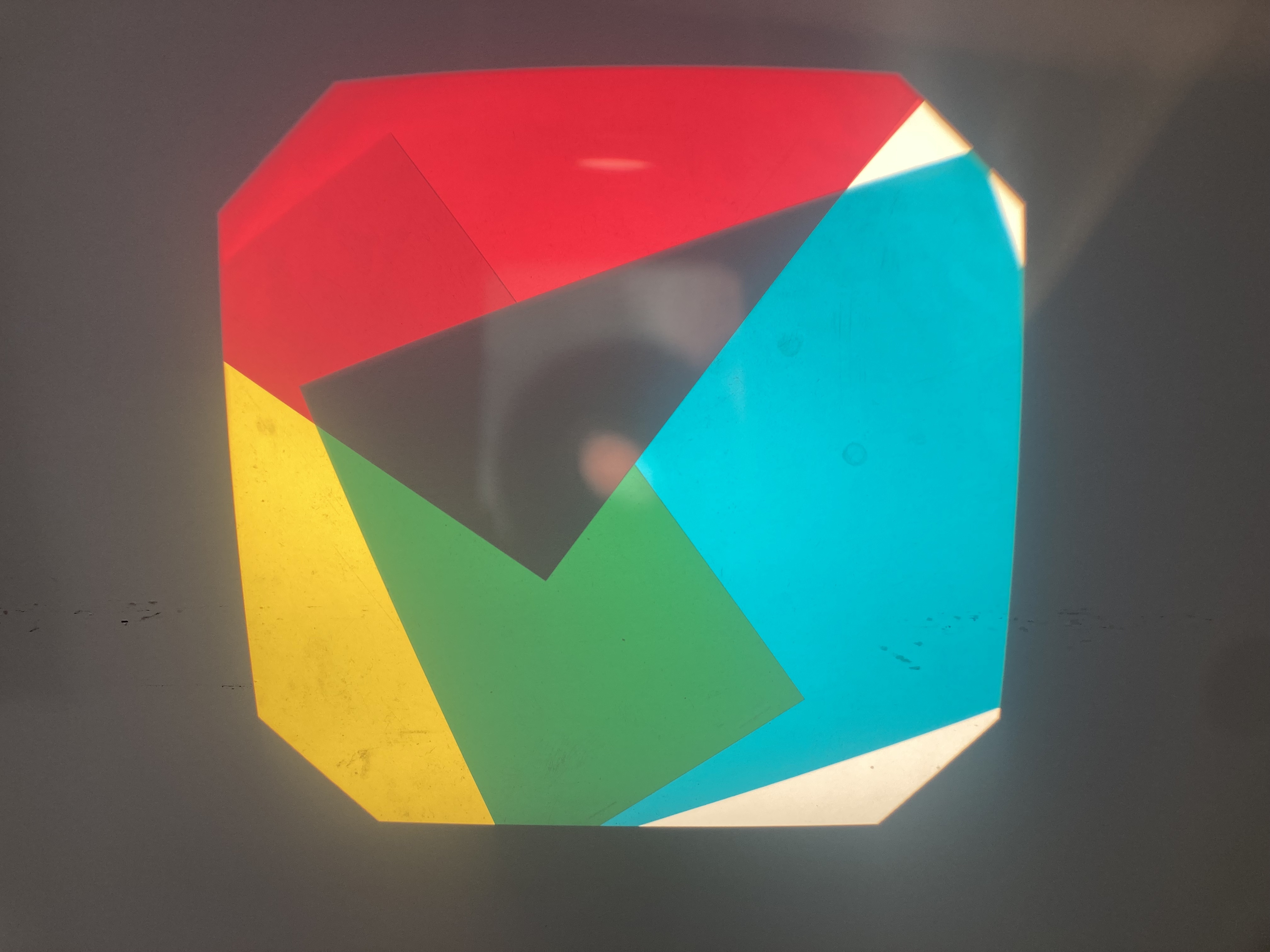 IMG_5686.jpg Overhead projector showing a red, blue and yellow transparency projected onto a wall.