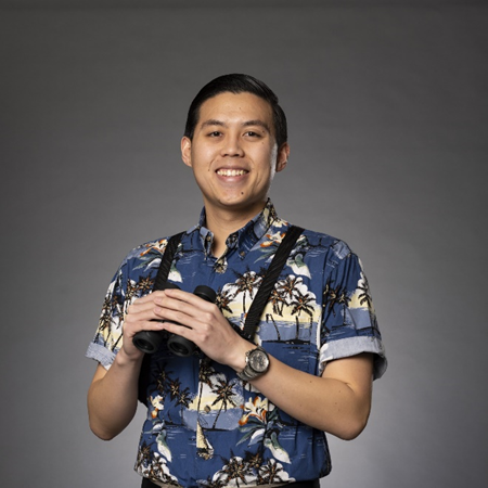 Man with binoculars in front of gray background