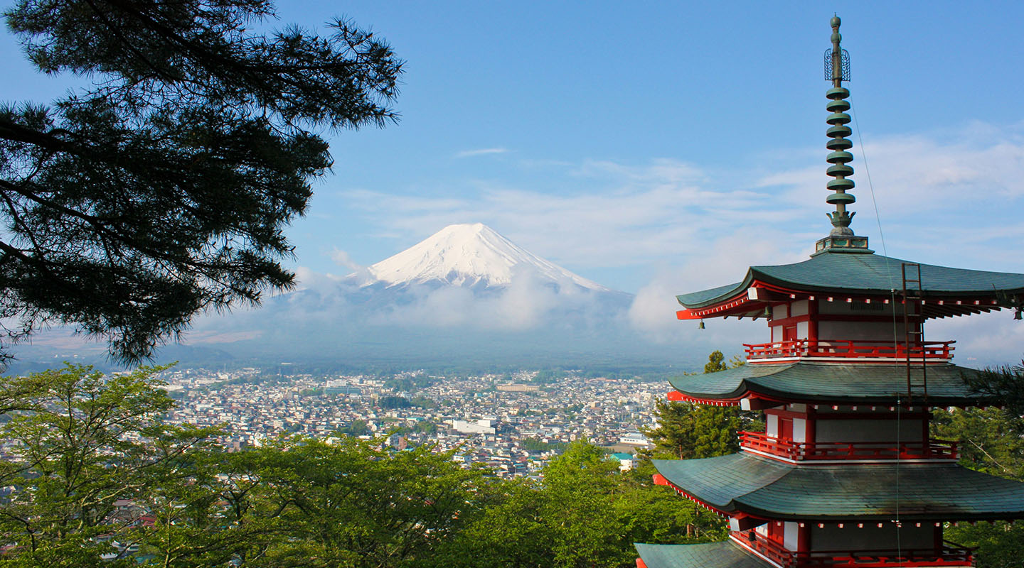 a view of Mt Fuji in Japan with traditional red pagoda building in foreground