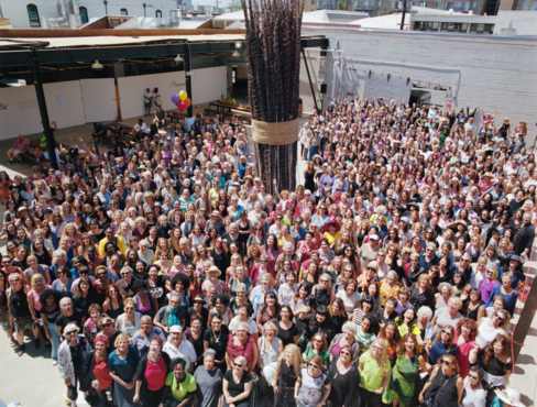 A large crowd of people standing together around an art sculpture
