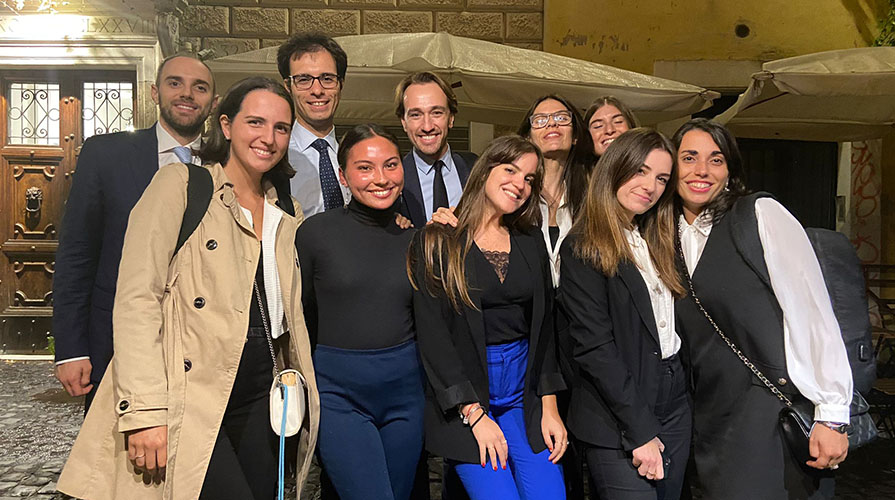 A group of Italian colleagues posing on a Roman street at night