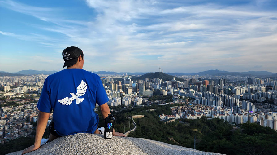 a young man from the back looking over a vista of Seoul's downtown