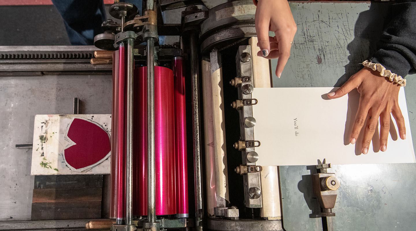 Occidental College students using the letterpress printer at the Lowercase studio on campus