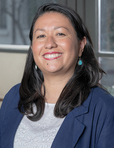 Carla Macal headshot with dark blue blazer