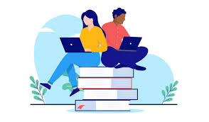 A female and a male sitting on a stack of books looking at their laptops
