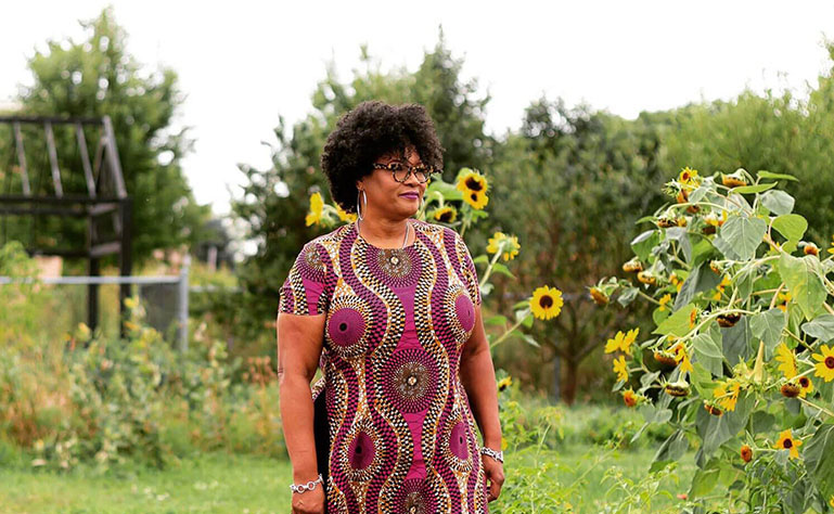 monica white in a green farm with sunflowers