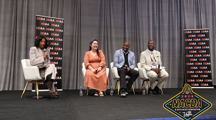 Awardees at the ceremony, four people seated on a stage