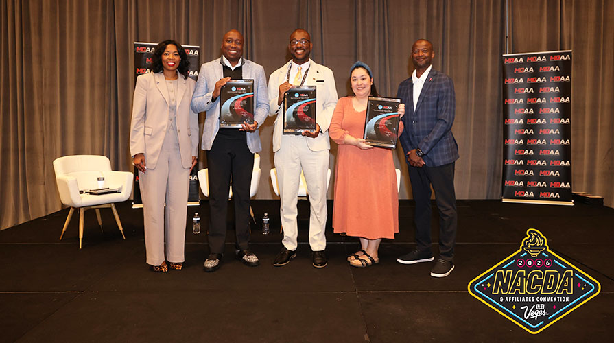 Four awardees standing together holding up their awards