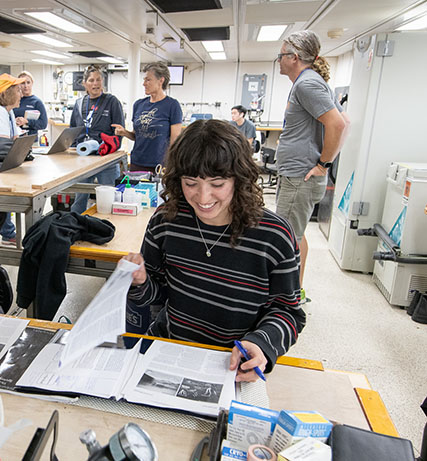 Bianca Dal Bo '24 looking at her research materials in a lab setting