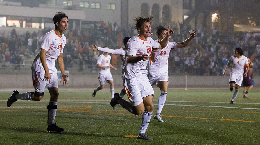 Occidental College men's soccer players in white jerseys out on the playing field
