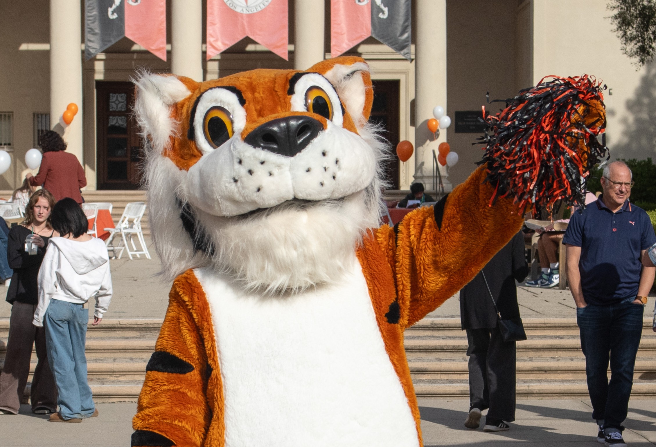 Oswald Waving as students and parents walk behind