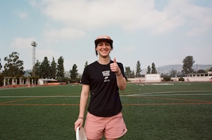 an occidental student wearing athletic attire and holding a frisbee on Patterson Field on Occidental's Los Angeles Campus