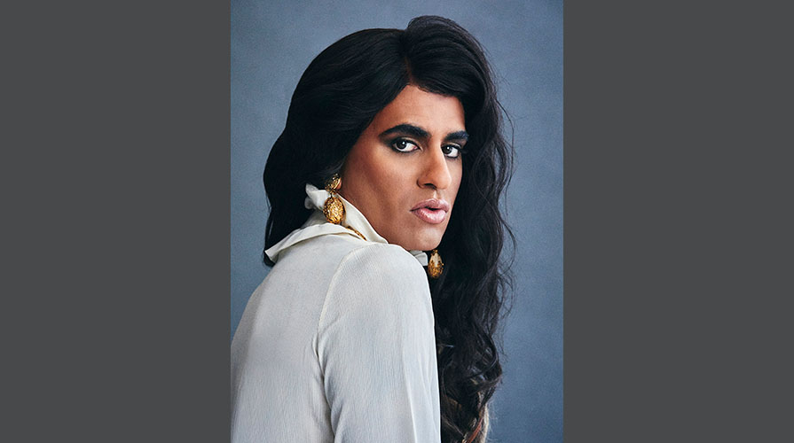 ALOK portrait with long black hair and a white top