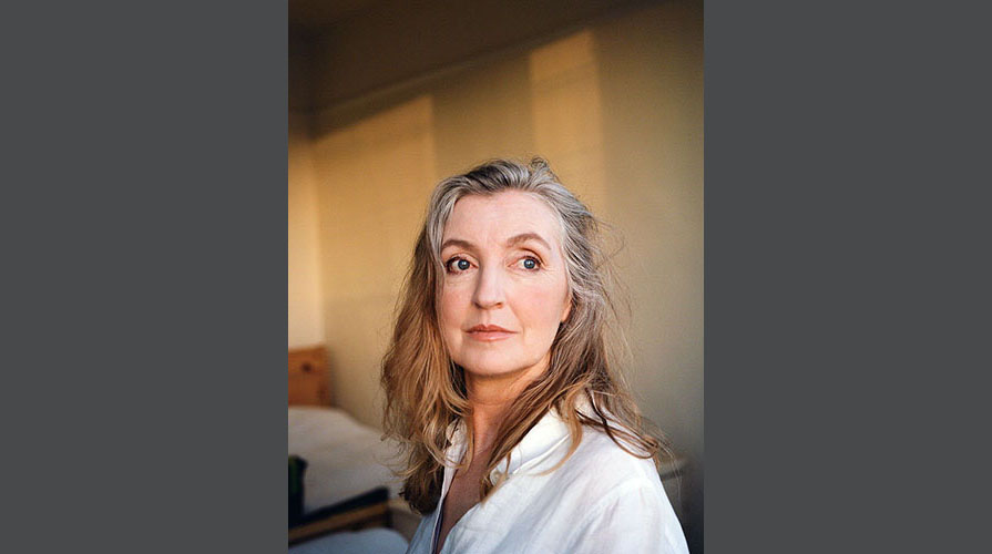 Portrait of Rebecca Solnit in the sunlight with a white top