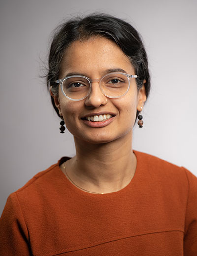 Natasha Sekhon headshot orange sweater