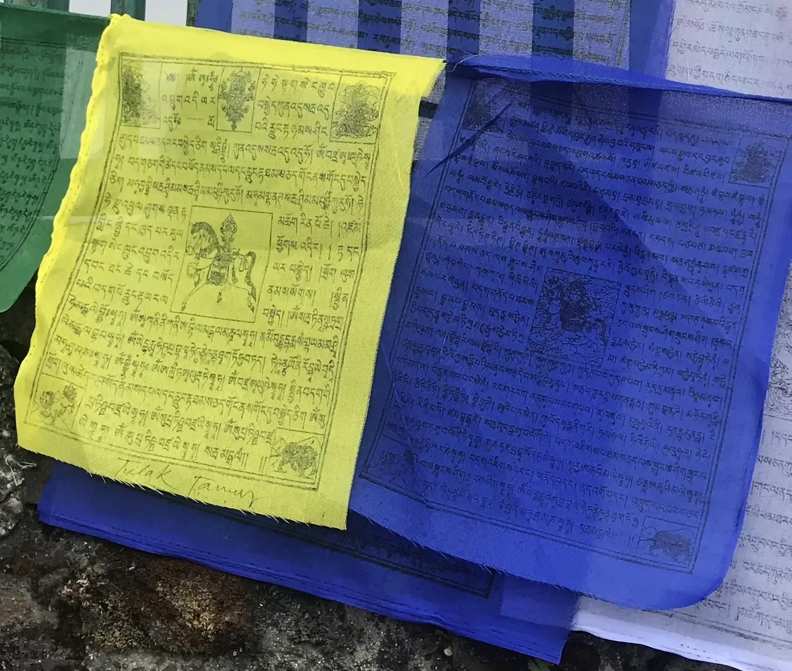 Prayer Flag 1.jpeg Close up photo of prayer flags, one yellow one blue.