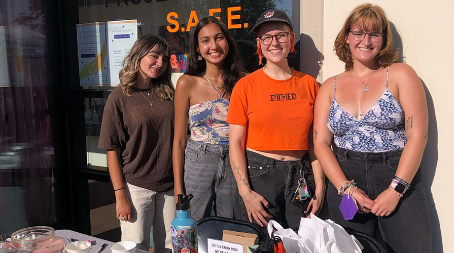 Four staff members from Project SAFE posing together at a table