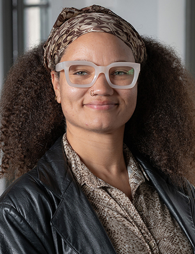 Summer Sloane-Britt headshot with black jacket and glasses
