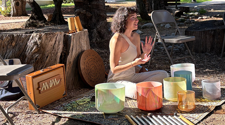 a woman with crystal bowls presiding over an outdoor sound bath on the Oxy campus