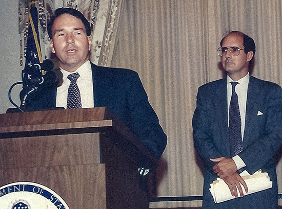Speaking at his swearing-in as U.S. ambassador to Finland in 1994 at the State Department in Washington, D.C., as Strobe Talbott, deputy secretary of state (and his brother-in-law), looks on.